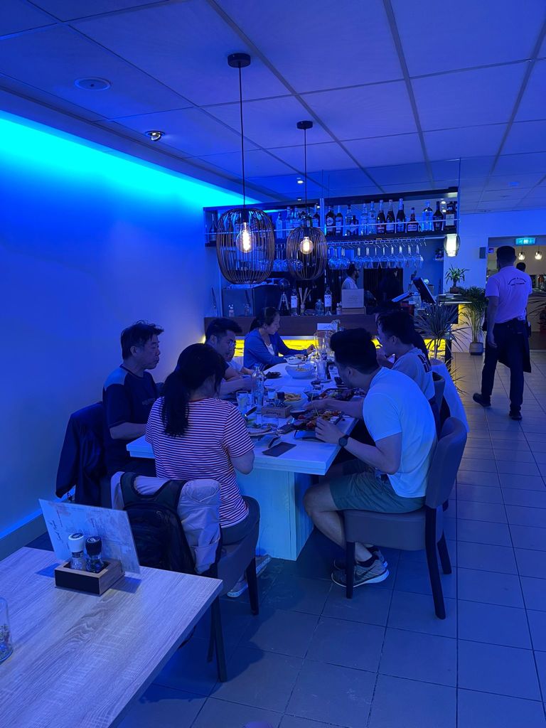 Klanten aan het eten binnen bij restaurant Saint Tropez.